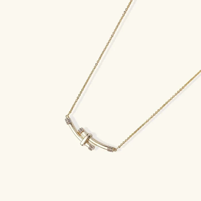 Bamboo Arc Necklace with a gold-tone fine chain and curved crossed bars, accented by small clear stones at the ends.