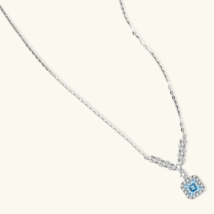 Celestial Arc Moissanite Necklace in silver with a delicate chain, blue square-cut pendant and clear stone halo