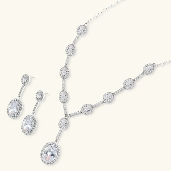 Celestial Cascade CZ Necklace set in silver-tone metal with a crystal-studded Y-shaped chain, pear pendant and matching drop earrings