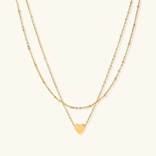 Layered Heart Necklace in gold-tone metal with two delicate chains, one beaded, and a small polished heart pendant.