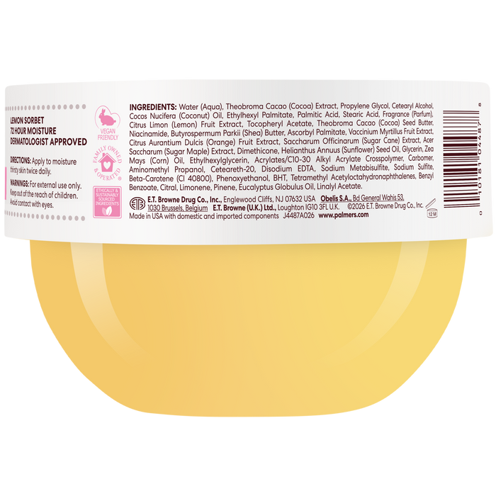 Close-up of the back of a round container showing a white label with black text, a barcode, and a yellow circular graphic at the bottom. The label includes product details such as scent notes, ingredients and directions.