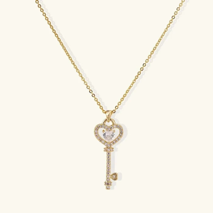 Secret Heart Key Necklace with a gold-tone chain and heart-topped key pendant, clear pavé stones and heart-cut center