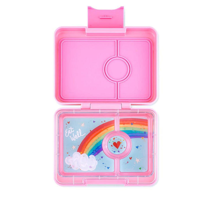 A pink Yumbox Lunch Snack Size Bento Lunch Box with a 3-compartment food tray, including illustrations on the lid and a rainbow and cloud motif on the tray.